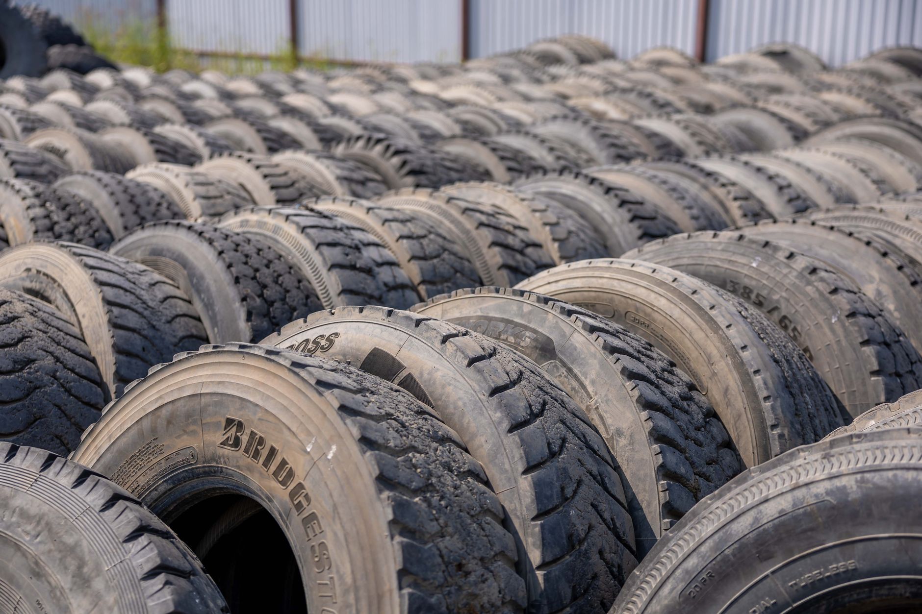 Stacked used tires in an industrial yard