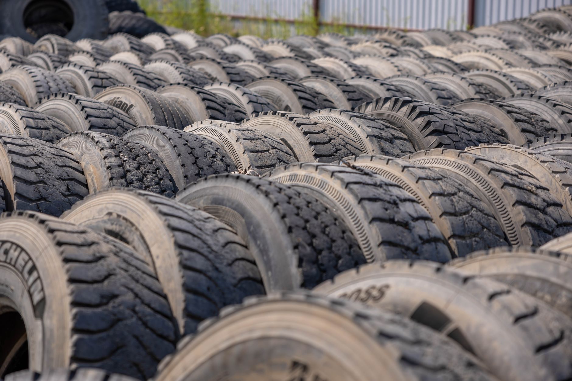Rows of used tires stacked in an outdoor storage yard