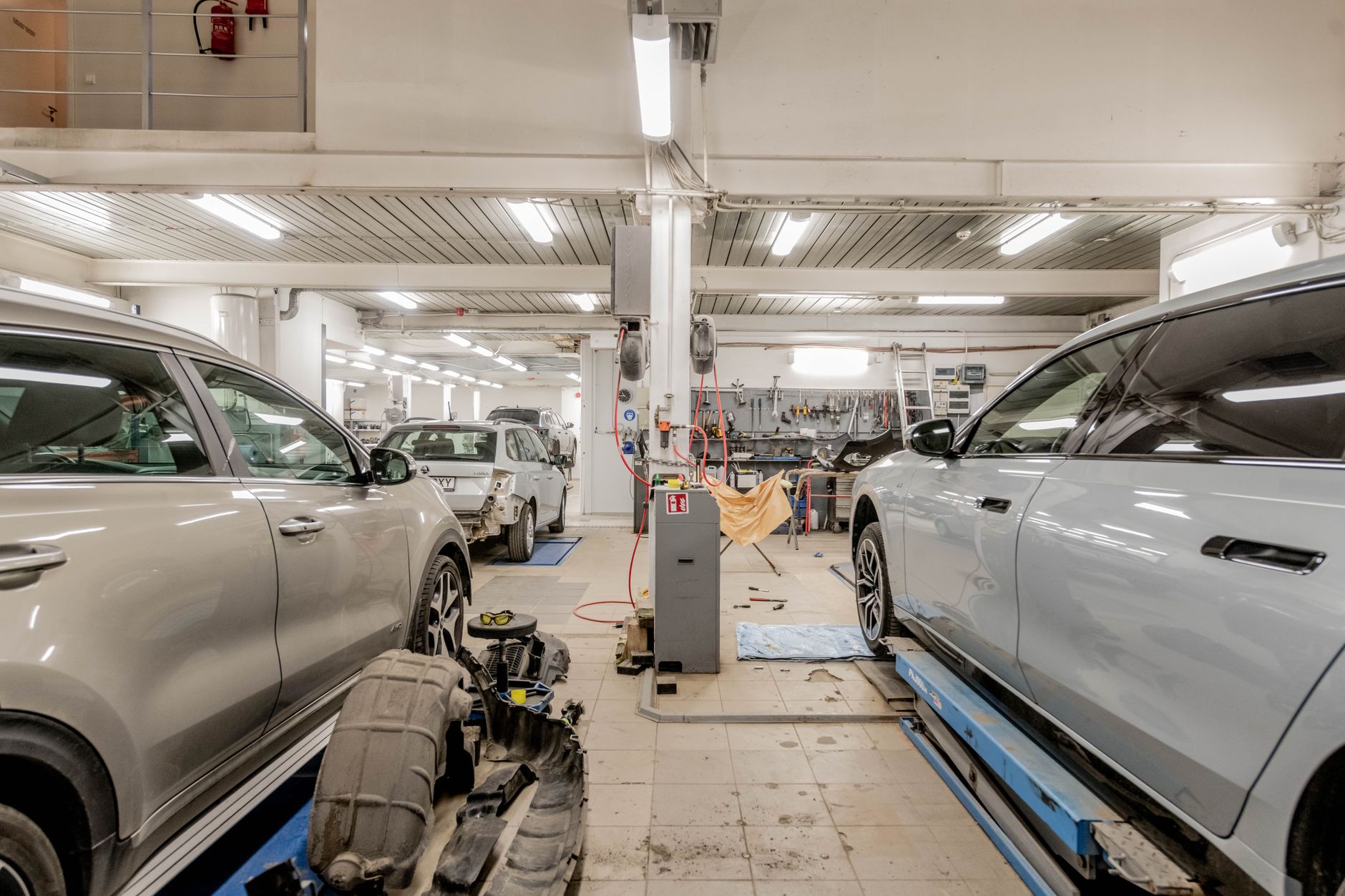 Interior of an automotive repair shop with cars being serviced