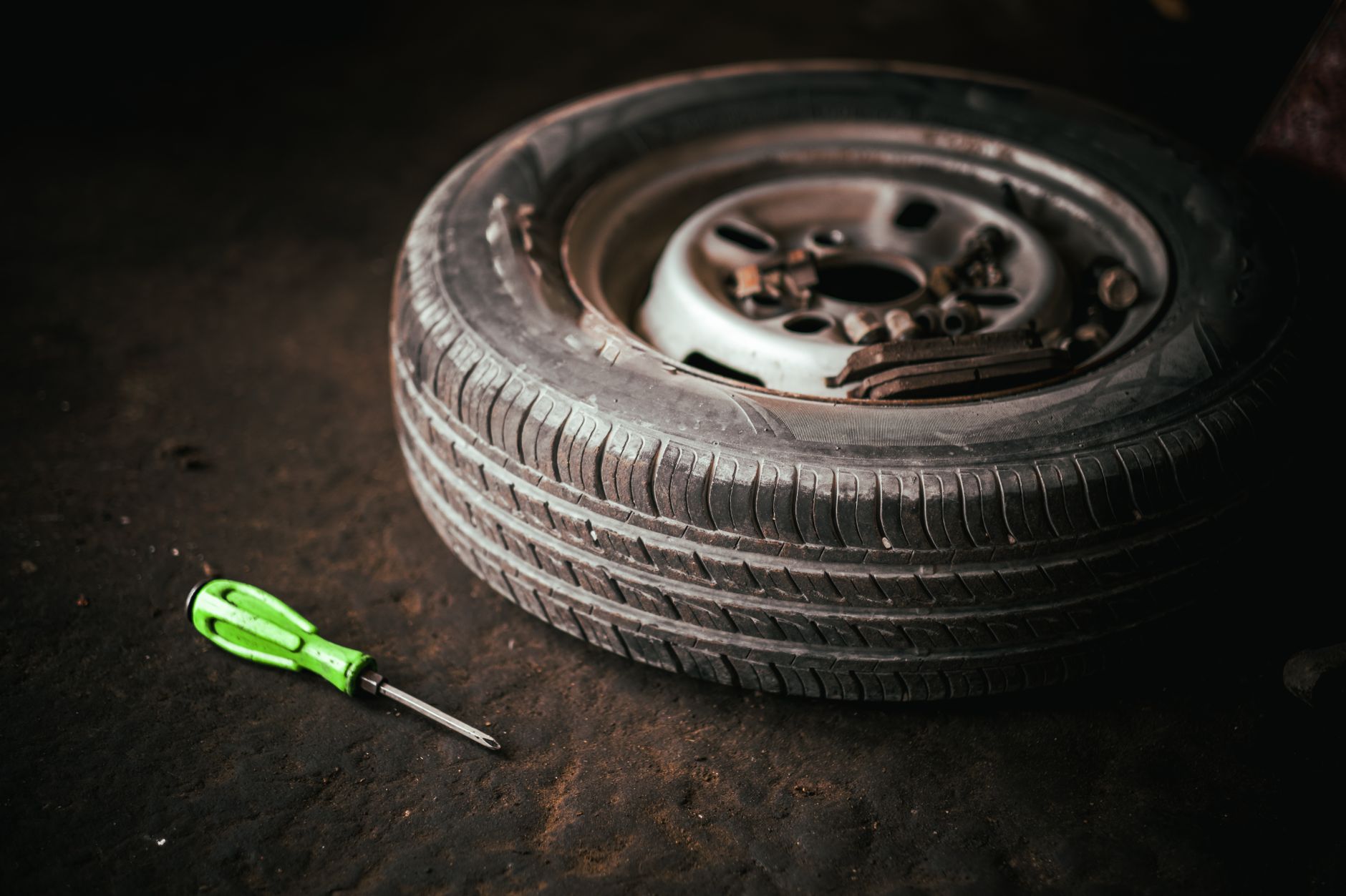 A tire and tools on the floor of a busy automotive repair garage