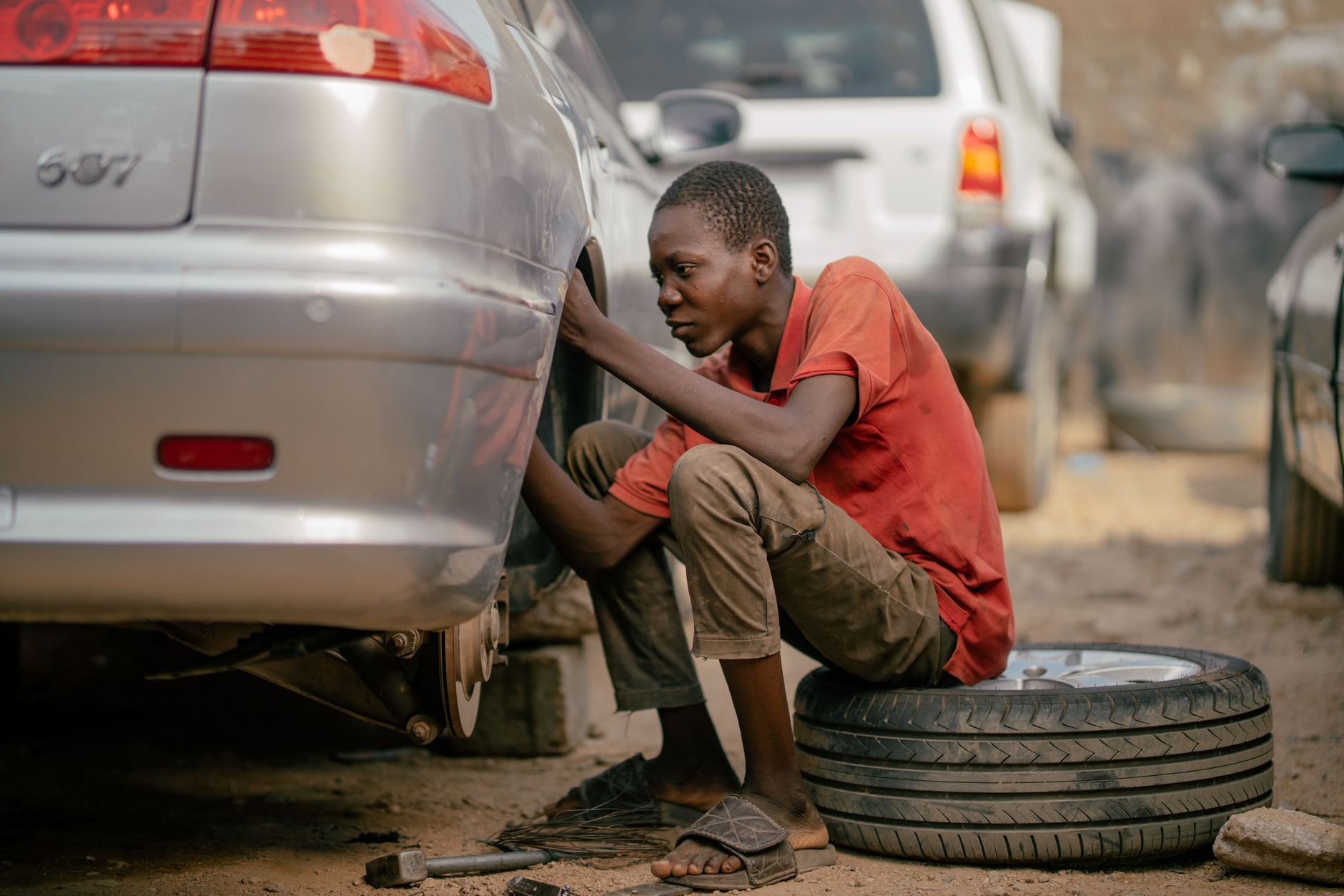 Mechanic repairing a car tire in an outdoor garage