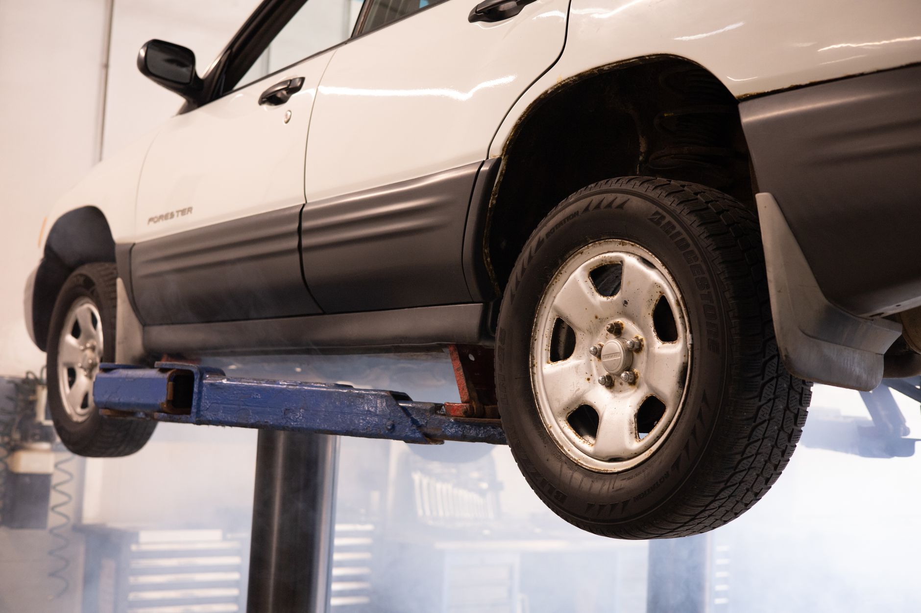 Car raised on a lift in an automotive repair shop