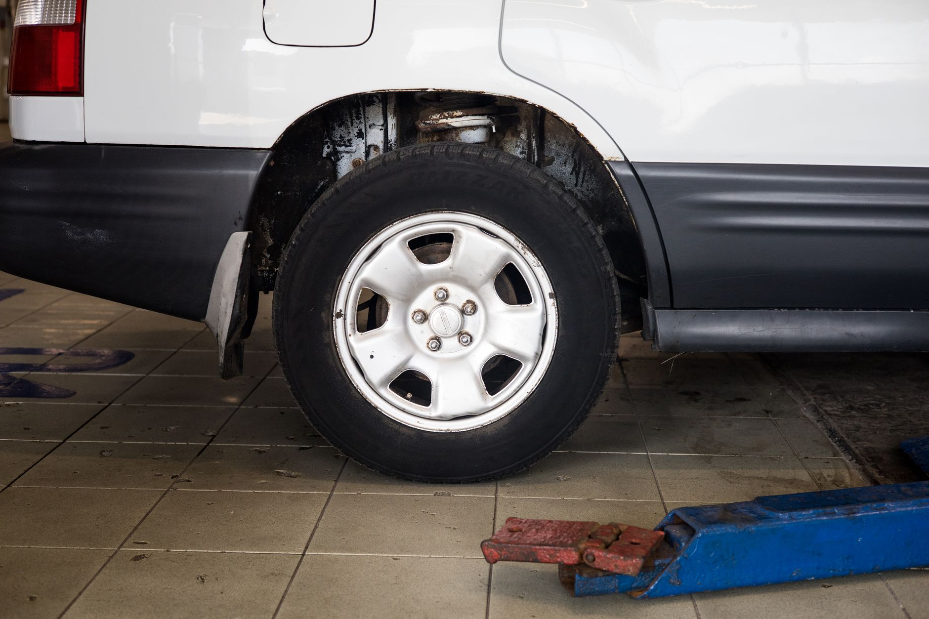 Close-up of a car wheel on a hydraulic jack during alignment service